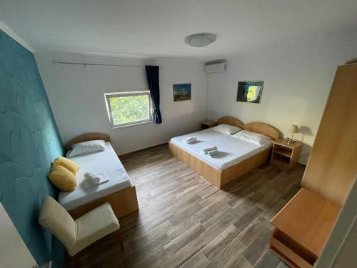 ein Zimmer mit 2 Betten und einem Stuhl darin in der Unterkunft Apartments Mila - Mala Duba in Živogošće