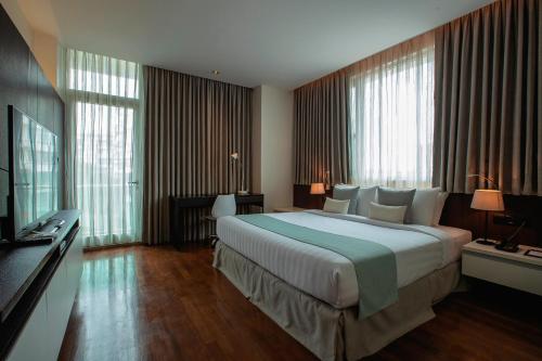 Habitación de hotel con cama grande y ventanas en Residence26 en Yangón