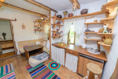 una cocina con estanterías de madera y una mesa en una habitación en Екосадиба Лісова Казка, en Dmitrenki