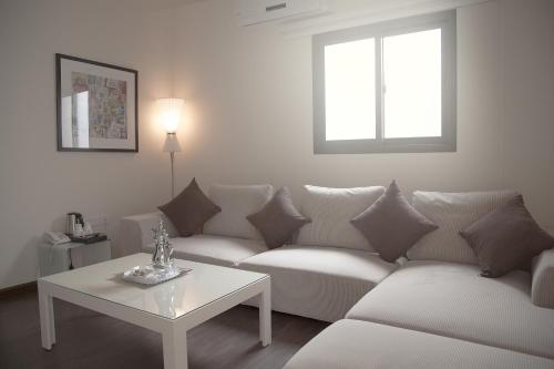 a white living room with a couch and a table at Rafa Homes in Riyadh
