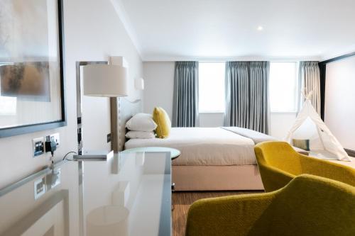 a hotel room with a bed and a chair at Royal Berkshire in Ascot
