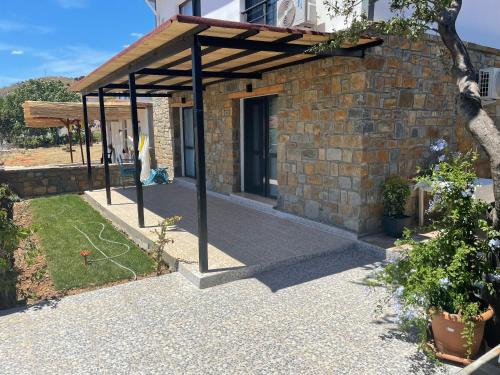 a brick building with a wooden roof on a patio at Imbrossa Hotel in Gokceada Town