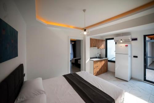 eine Küche mit einem Bett und einem weißen Kühlschrank in der Unterkunft Imbrossa Hotel in Gokceada Town
