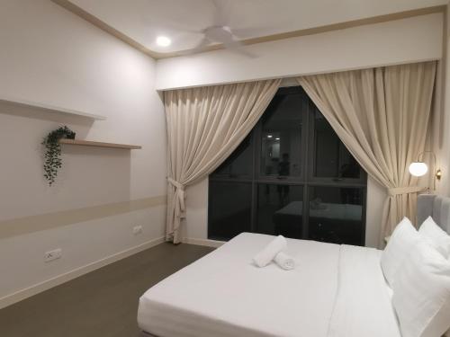 a bedroom with a white bed and a window at The Ooak Suites and Residence@ Kiara 163 in Kuala Lumpur