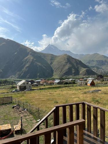 a view of a field with mountains in the background at Kazbegi 4 side cottages in Stepantsminda