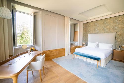 聖艾米隆的住宿－Château de Ferrand，酒店客房配有一张床、一张书桌和一张书桌。