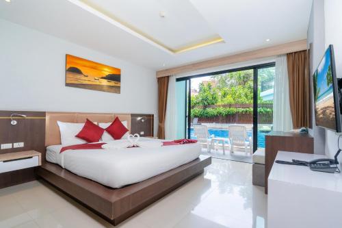 a bedroom with a bed and a desk and a television at Paripas Patong Resort - SHA Extra Plus in Patong Beach