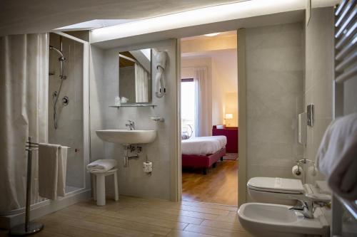 a bathroom with a sink and a shower and a toilet at Hotel Posta Panoramic Assisi in Assisi
