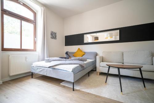 ein Wohnzimmer mit einem Bett und einem Sofa in der Unterkunft FULL HOUSE Studios - L96 2 Bedroom Apartment in Zwickau