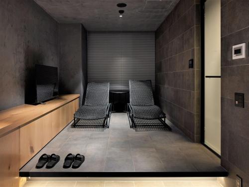 a conference room with two chairs and a table at hotel androoms Sapporo Susukino in Sapporo