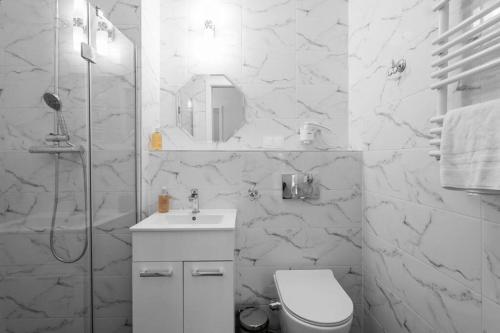a white bathroom with a toilet and a sink at GRANO FLATS Sobieszewo - Villa Neptun in Sobieszewo