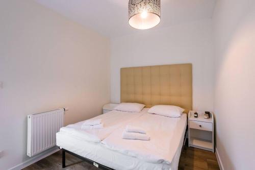 a small bedroom with a bed and a night stand at GRANO FLATS Sobieszewo - Villa Neptun in Sobieszewo