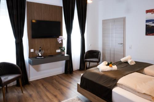 a bedroom with a bed with a television and a chair at Grand Hotel in Soltau