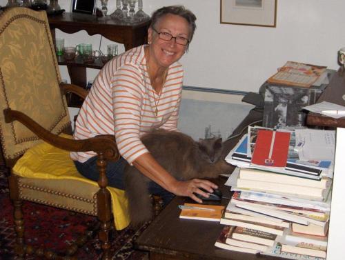 a woman sitting in a chair holding a cat at L'Hirondelle in Saint-Jacut-les-Pins