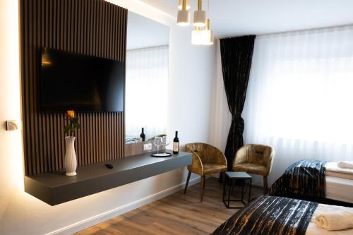 a hotel room with a bed and a desk with a television at Grand Hotel in Soltau