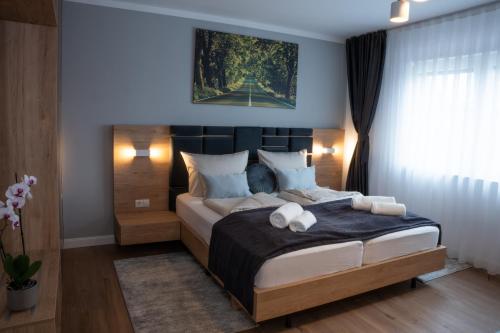a bedroom with a large bed and a painting on the wall at Grand Hotel in Soltau