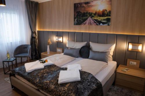 a bedroom with a large bed with two towels on it at Grand Hotel in Soltau