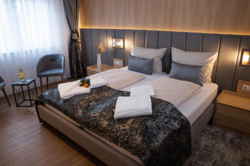 a bedroom with a large bed with towels on it at Grand Hotel in Soltau