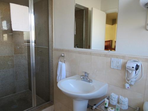 uma casa de banho com um lavatório e um chuveiro em Coronet Motel em Palo Alto