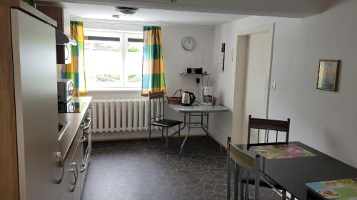 um quarto com uma cozinha com uma mesa e uma janela em Ferienwohnung Schaarschmidt em Kurort Altenberg