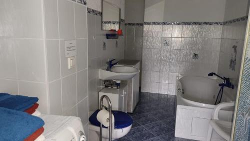 ein Badezimmer mit zwei Waschbecken, einer Badewanne und einem WC in der Unterkunft Ferienwohnung Schaarschmidt in Kurort Altenberg