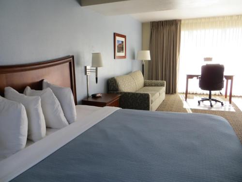 Habitación de hotel con cama y silla en Coronet Motel en Palo Alto