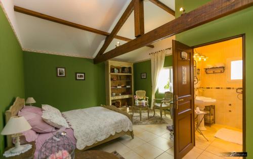 Cussac的住宿－LE BOUILLARY，一间带绿色墙壁的卧室、一张床和一间餐厅