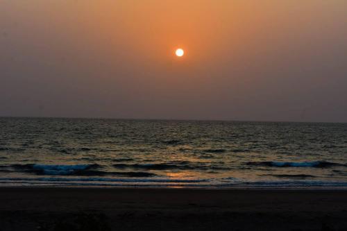 a sunset over the ocean with the sun in the sky at Chivarin Resorts in Malvan