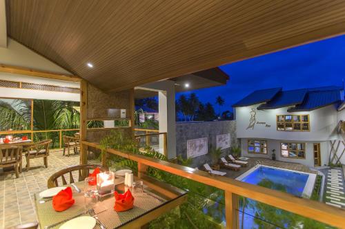 an outdoor patio with a table and a swimming pool at Kaani Village & Spa in Maafushi