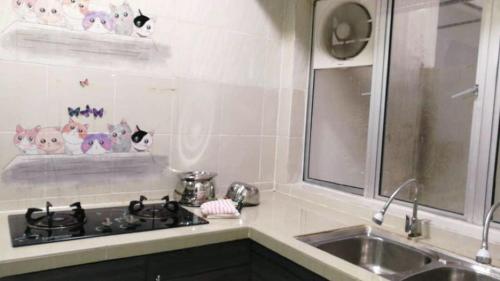 a kitchen with a sink and a counter with cats on the wall at SA @ Cameron Emerald Avenue in Brinchang