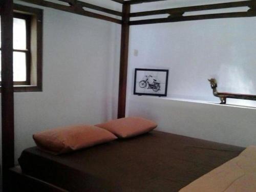 - un lit avec un oreiller orange au-dessus de la chambre dans l'établissement Room in BB - villas in batu indonesia homestay, à Kotalama