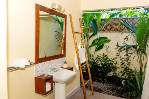 W łazience znajduje się umywalka i lustro. w obiekcie Balai sa Baibai w Mambajao