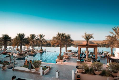 ein Resort mit Palmen und einem Pool in der Unterkunft Anantara Eastern Mangroves Abu Dhabi in Abu Dhabi