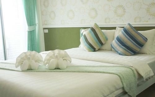 two stuffed animals sitting on top of a bed at Westgate Residence Hotel in Ban Bang Kho