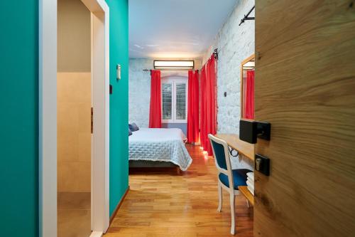 a bedroom with a bed and a desk in a room at Domus Maritima in Trogir