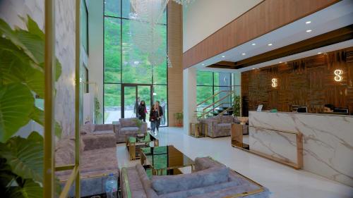 a lobby with couches and people walking in a building at Marco Polo Resort Kaghan in Kāgān