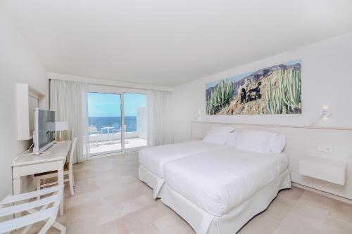 a white bedroom with a bed and a television at Iberostar Selection Lanzarote Park in Playa Blanca