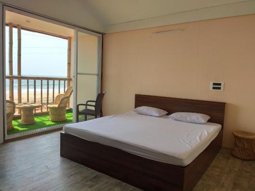 a bedroom with a bed and a balcony at Chivarin Resorts in Malvan