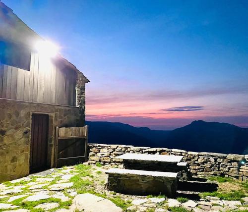 a building on top of a mountain at sunset at Tiñones cabaña pasiega in Valcaba