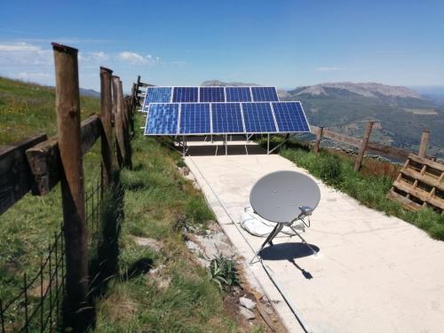 a table and a solar array on top of a mountain at Tiñones cabaña pasiega in Valcaba