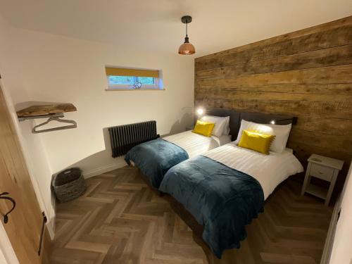 two twin beds in a room with wooden floors at Cedar Lodge in Crawshaw Booth
