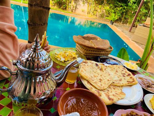 una mesa con comida, una tetera y pan en Villa Aïcha, en Marrakech