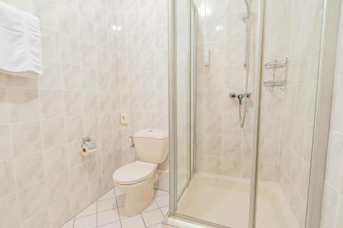 a bathroom with a toilet and a glass shower at Hôtel Le Petit Poète in Echternach