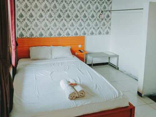 een slaapkamer met een bed met handdoeken erop bij De Luck Homestay near Alun Alun Sidoarjo Mitra RedDoorz in Sidoarjo