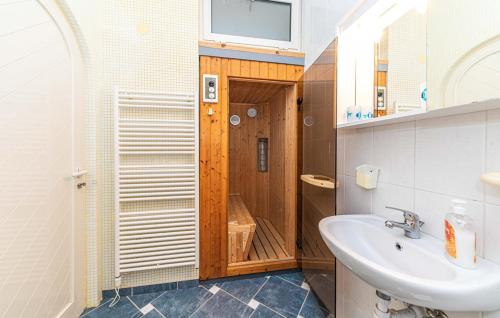 uma casa de banho com um lavatório e um chuveiro em Luksuzna villa sa privatnim unutarnjim bazenom Villa Garden em Podstrana