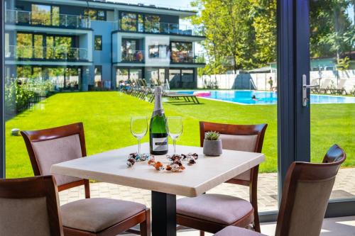 a white table with a bottle of wine and glasses at H55 in Balatonlelle