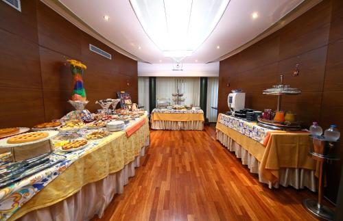 a large room with two tables with food on them at HR Hotel in Monfalcone