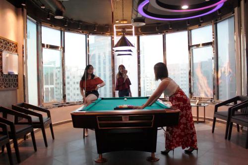 a group of women playing pool in a room with a pool table at Al Diar Dana Hotel in Abu Dhabi