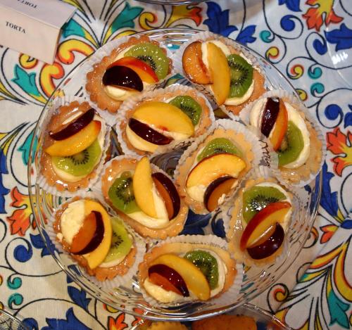 a glass plate of pastries with fruit on a table at HR Hotel in Monfalcone