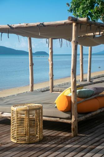 a bed on the beach with a surfboard at Selina Serenity Rawai Phuket in Rawai Beach